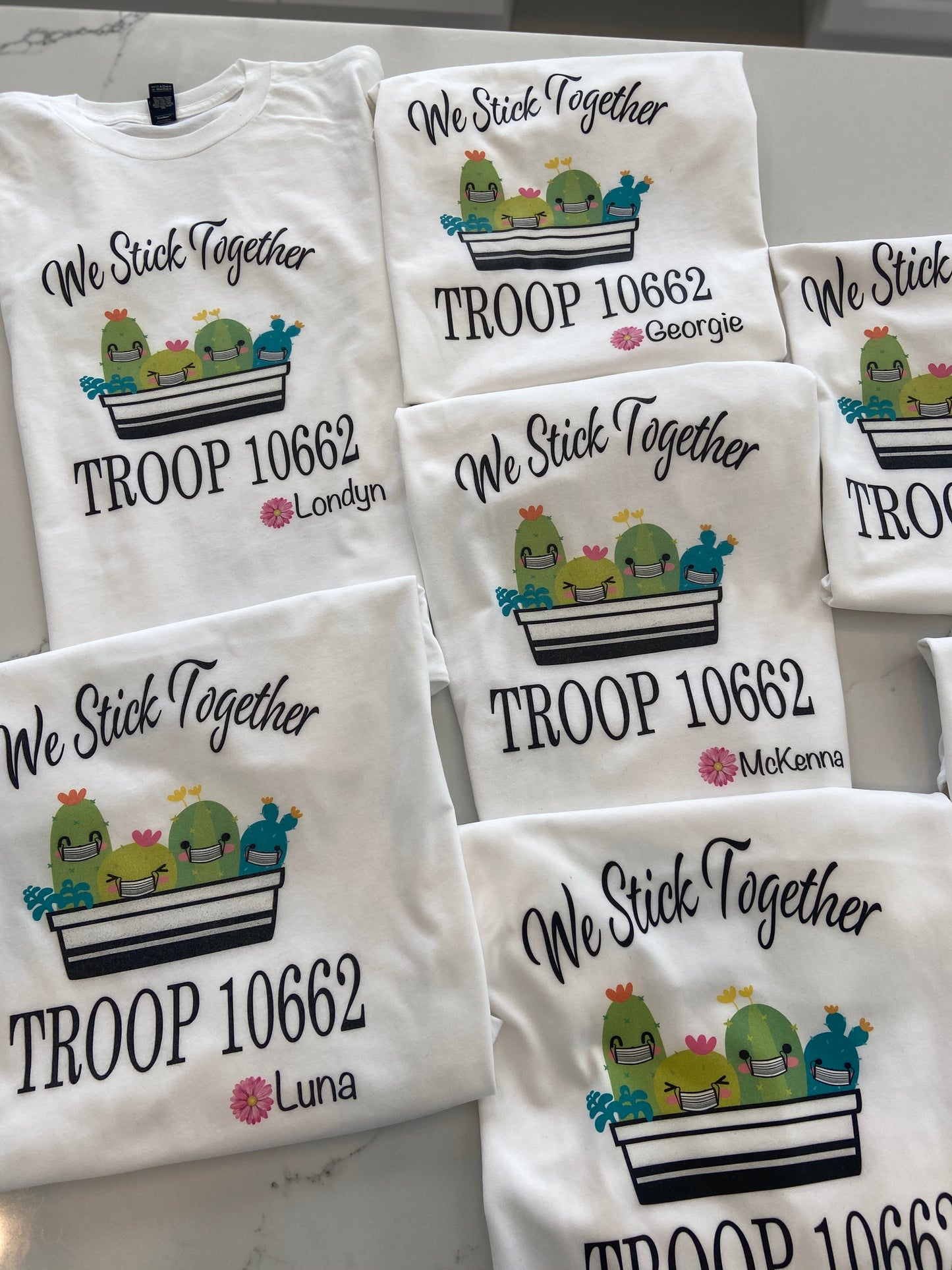 The cutest colorful Girl Scout Tees ! Personalized with troop number , masks or no masks and name   Cactus can be with or without masks - please note in personalization section when you check out   We stick together tee with names and troop number personalized on each shirt